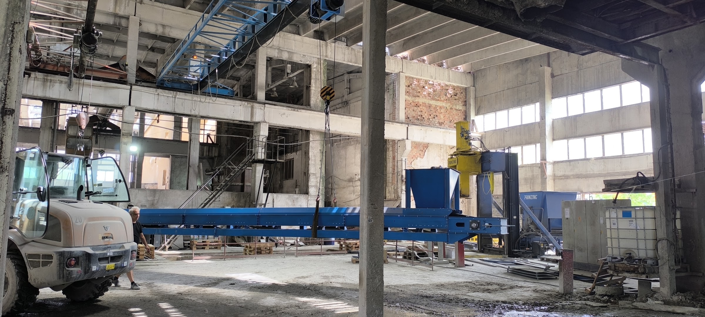 Позициониране на лентов транспортьор с бункер при монтаж в хале